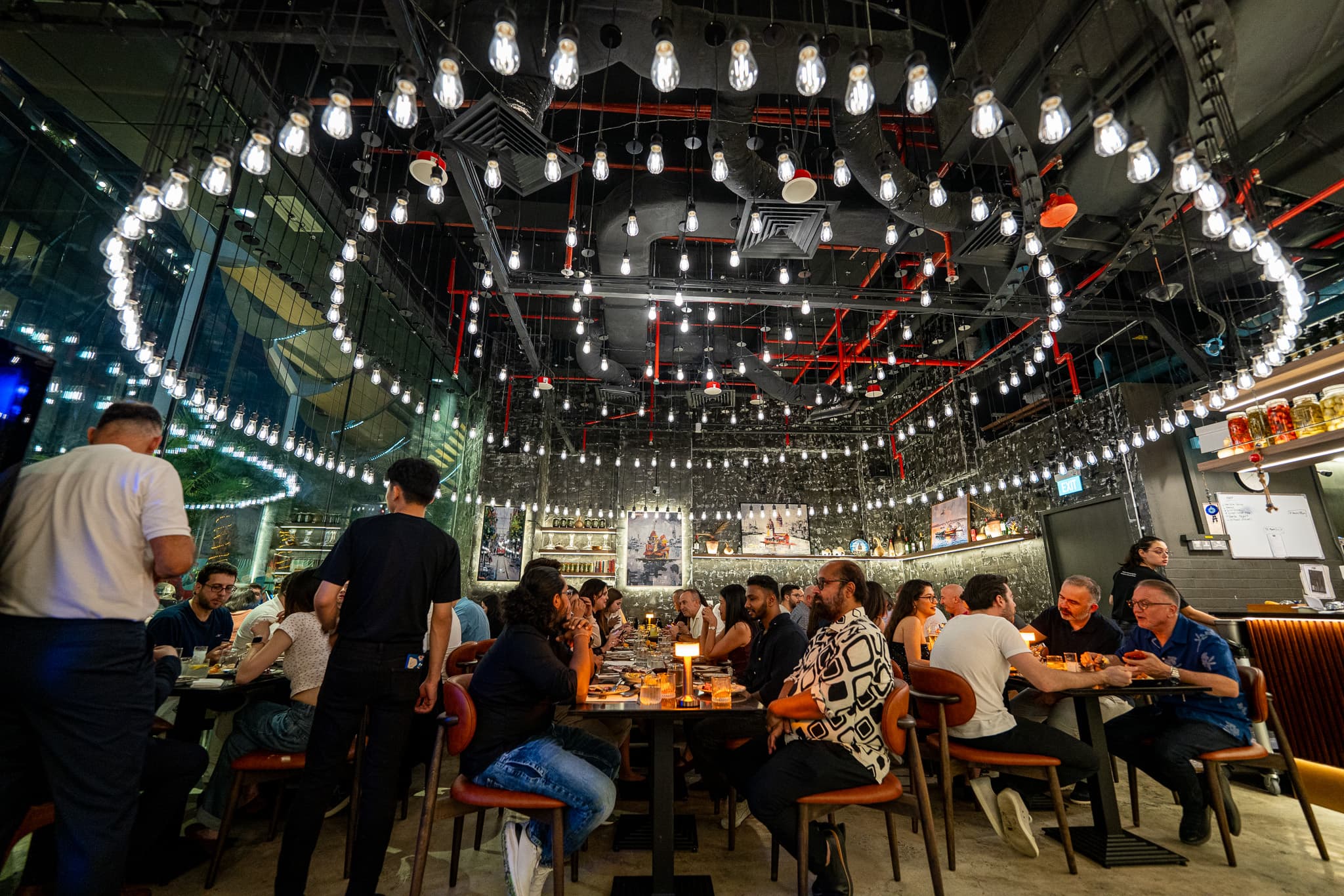 Guests dining beneath the covered terrace lights at Pera